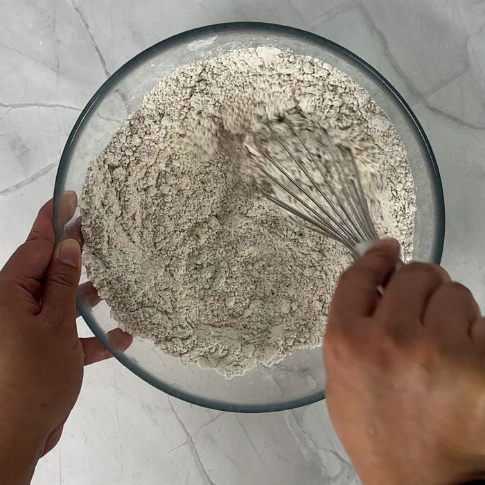 mixing dry ingredients in a large bowl with a whisk
