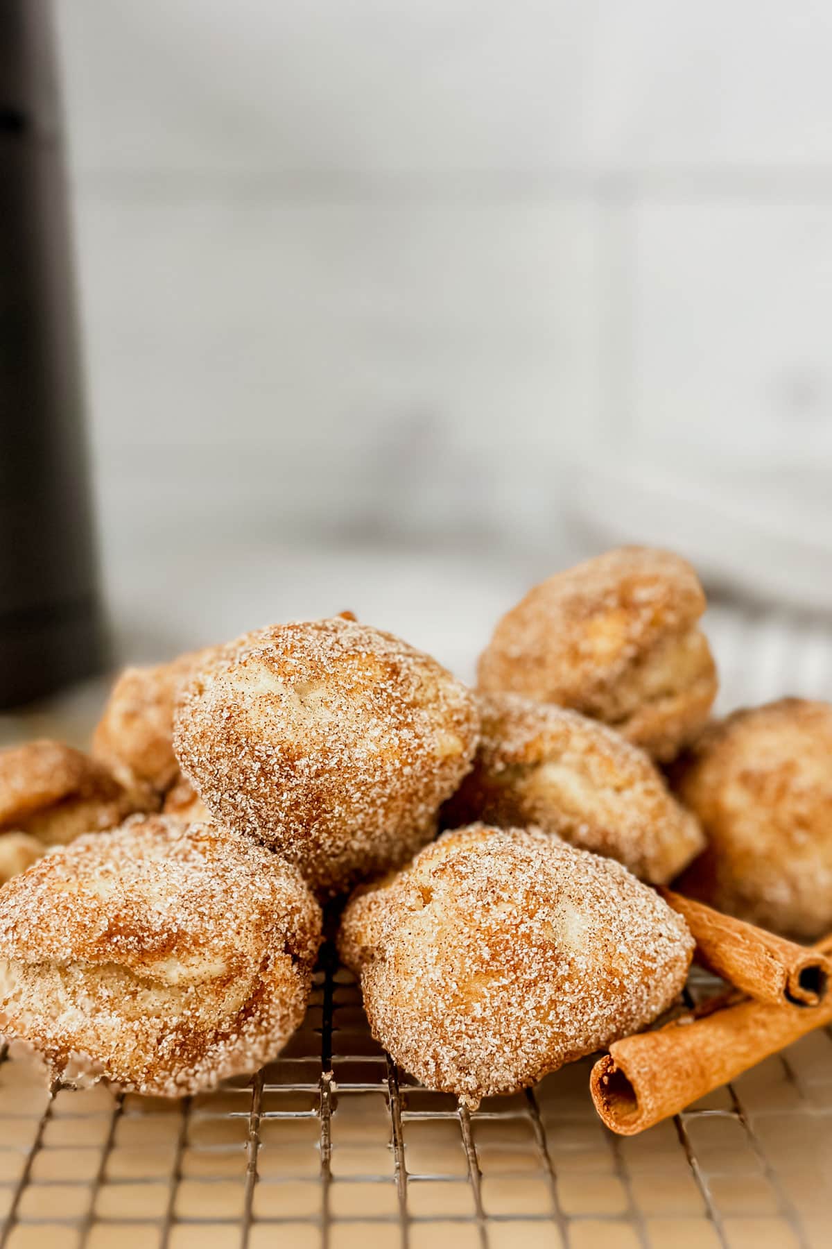 Air Fryer Banana Donuts covered in cinnamon sugar on a cooling rack