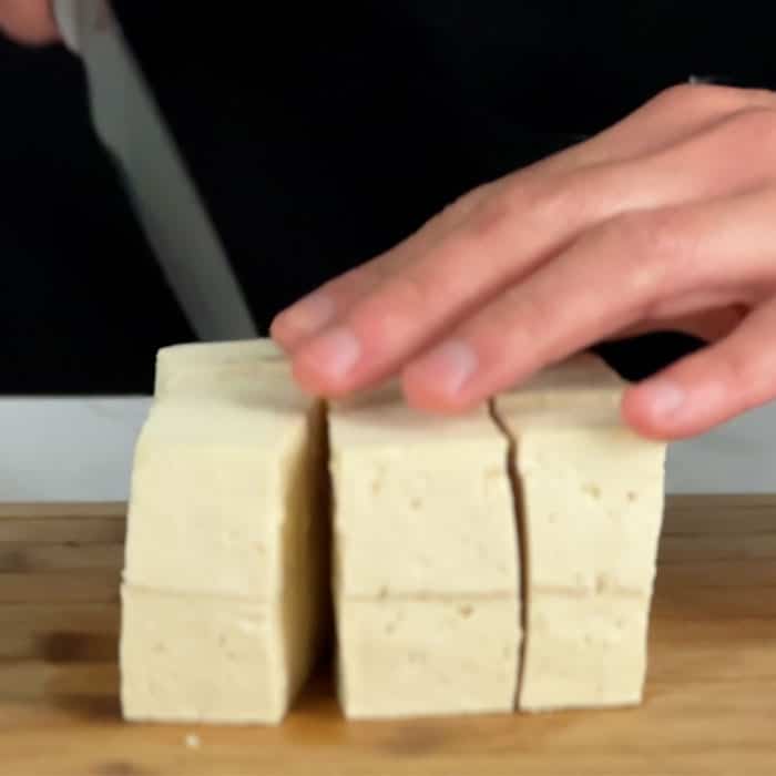 slicing tofu on a chopping board