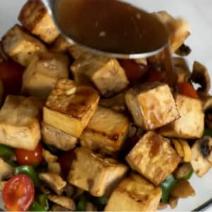mixing air-fried tofu, vegetables and sauce together