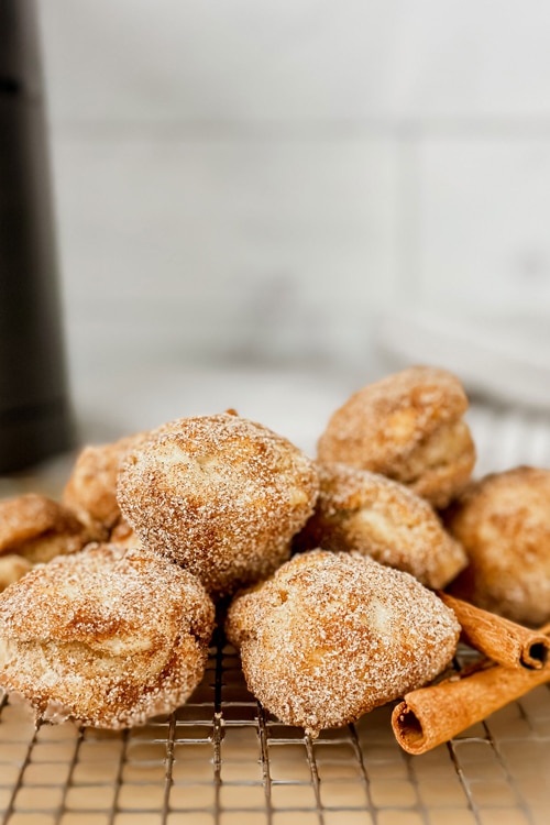 Air Fryer Banana Donuts covered in cinnamon sugar on a cooling rack