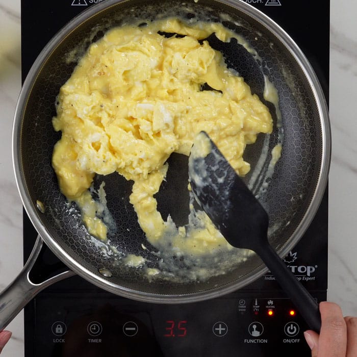 Cooking scrambled eggs in a pan.