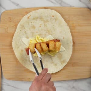 adding tater tots on breakfast burrito