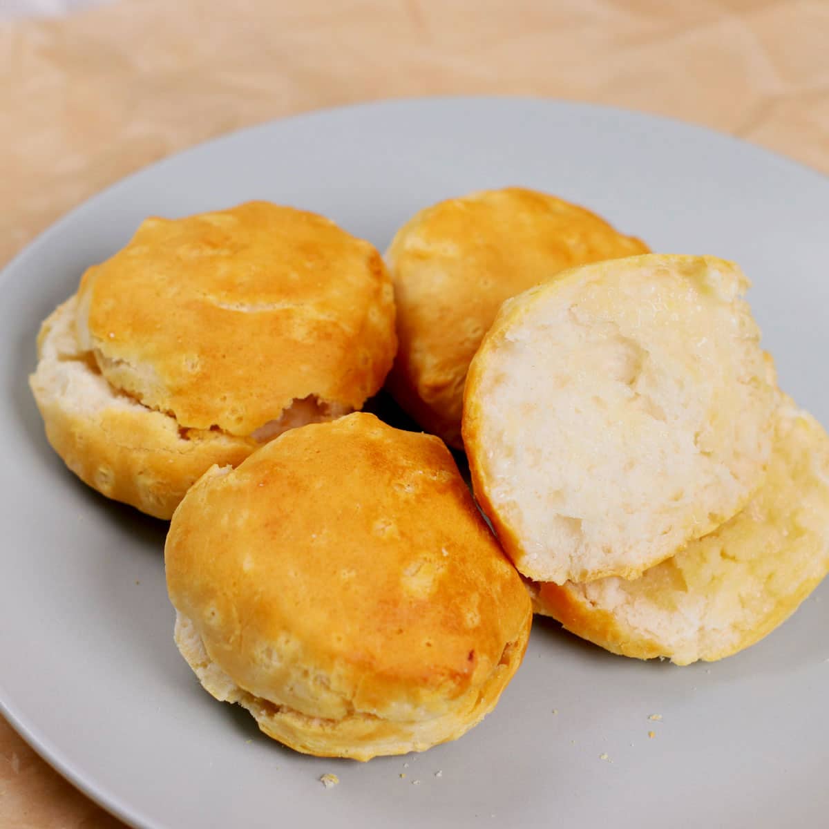 Air fried Pillsbury country biscuits with butter, served on a plate.