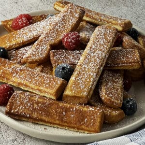 Air fryer frozen French toast sticks with berries and powdered sugar