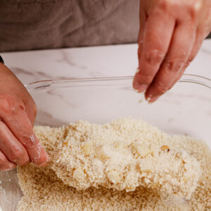 Putting together Korean mozzarella corn dog: adding dough, potato chunks, and bread crumbs