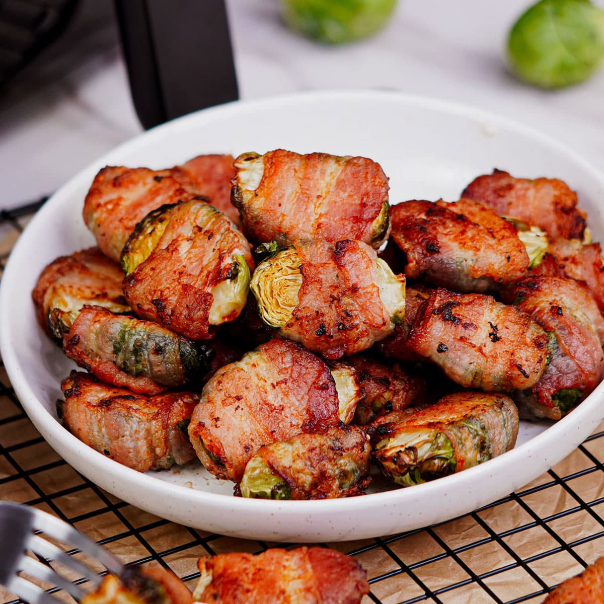 Air fried Bacon wrapped Brussels sprouts served in a plate.