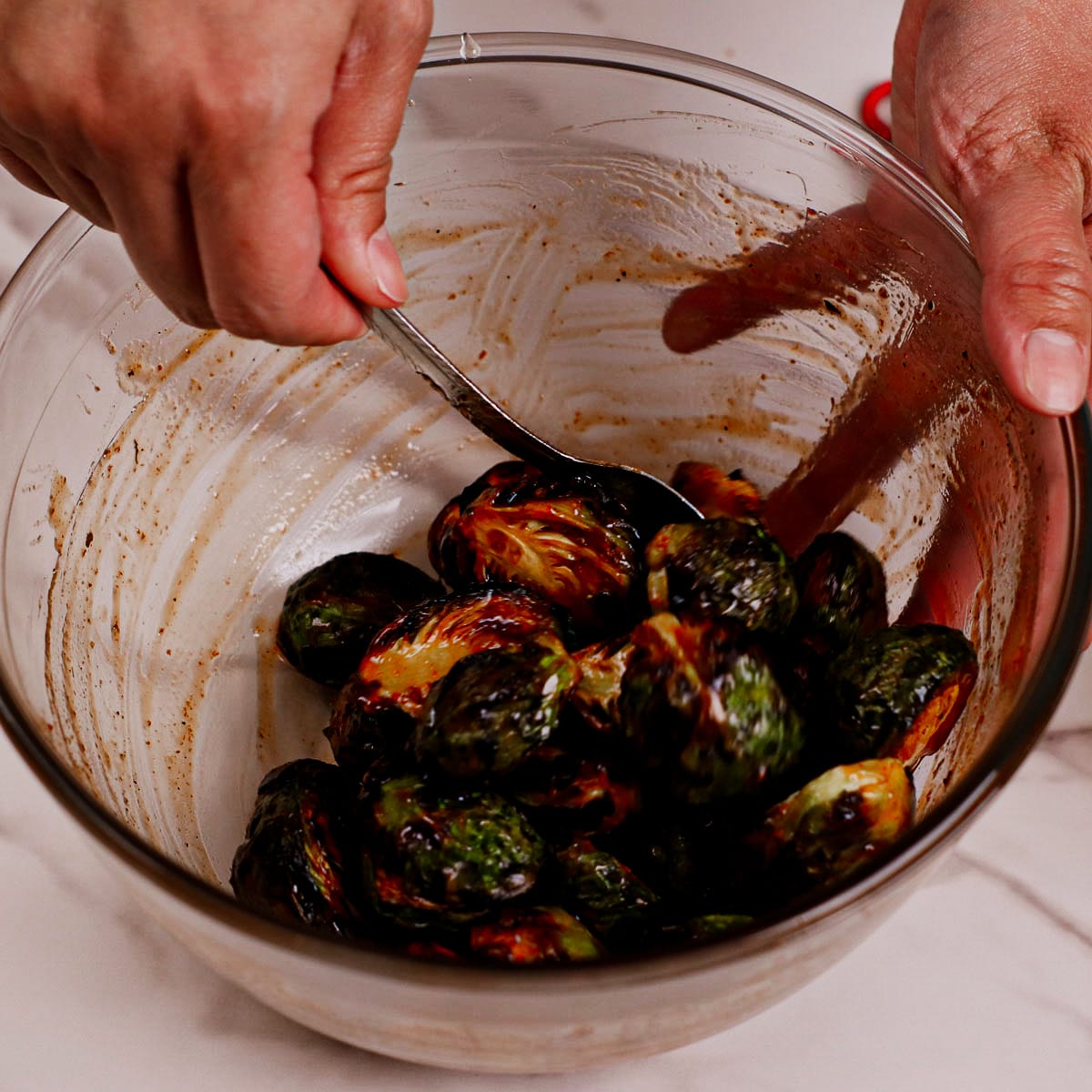 Coating roasted Brussels sprouts with honey sriracha sauce