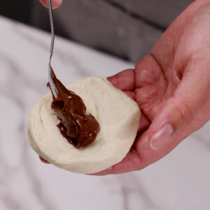 Adding Nutella filling to Pillsbury country biscuit dough.