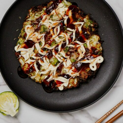 Air Fried Shaved Brussels Sprouts Okonomiyaki, with bonito flakes and green onion on the side