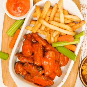 Air fried Buffalo chicken wings with fries, celery and carrots on the side.