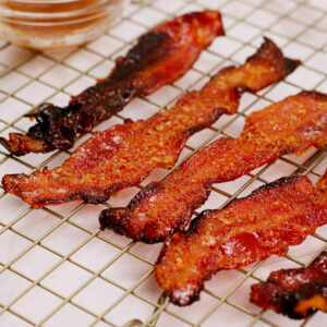 Air fried candy bacon on a cooling rack.