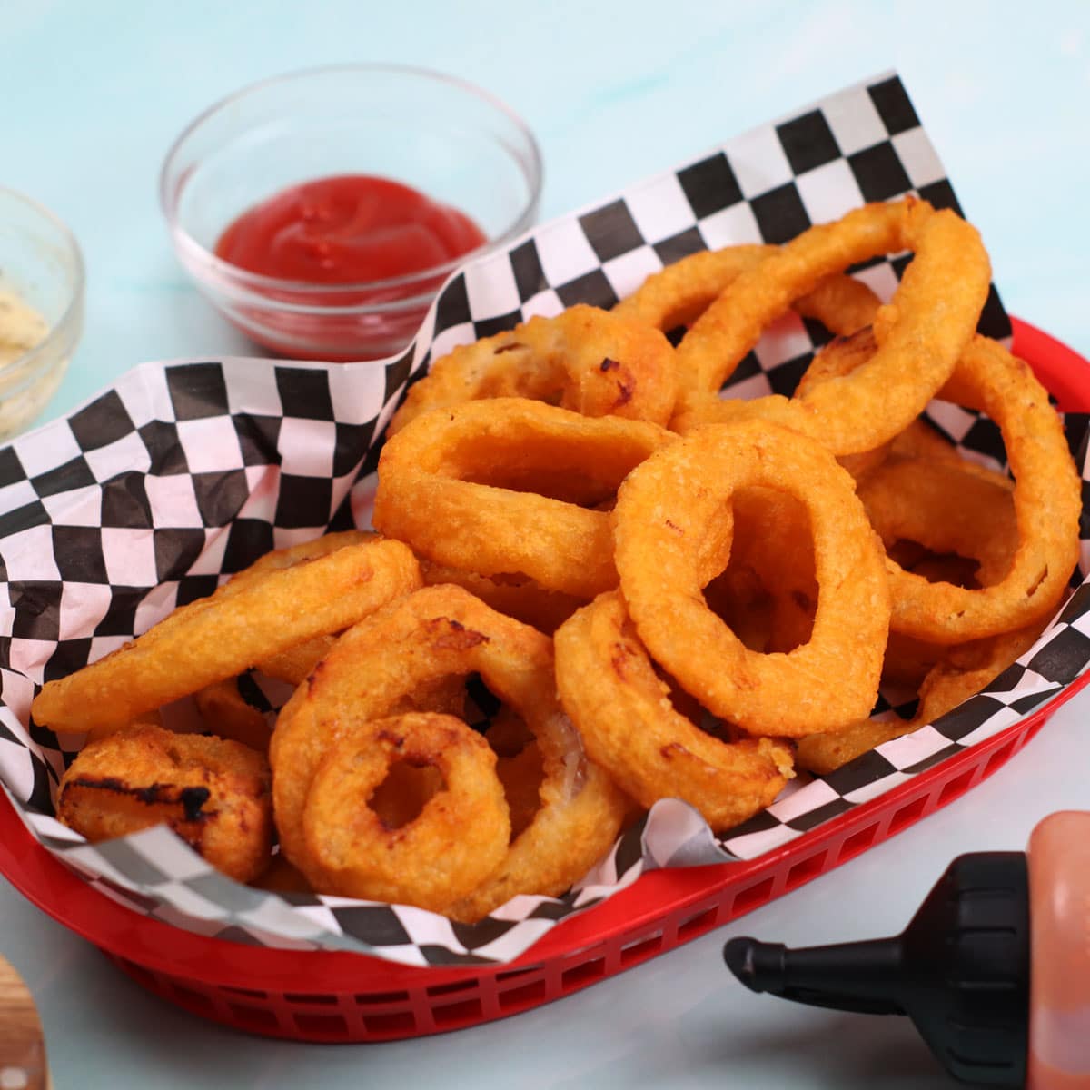 Air fried frozen onion rings in a traditional fast food basket.
