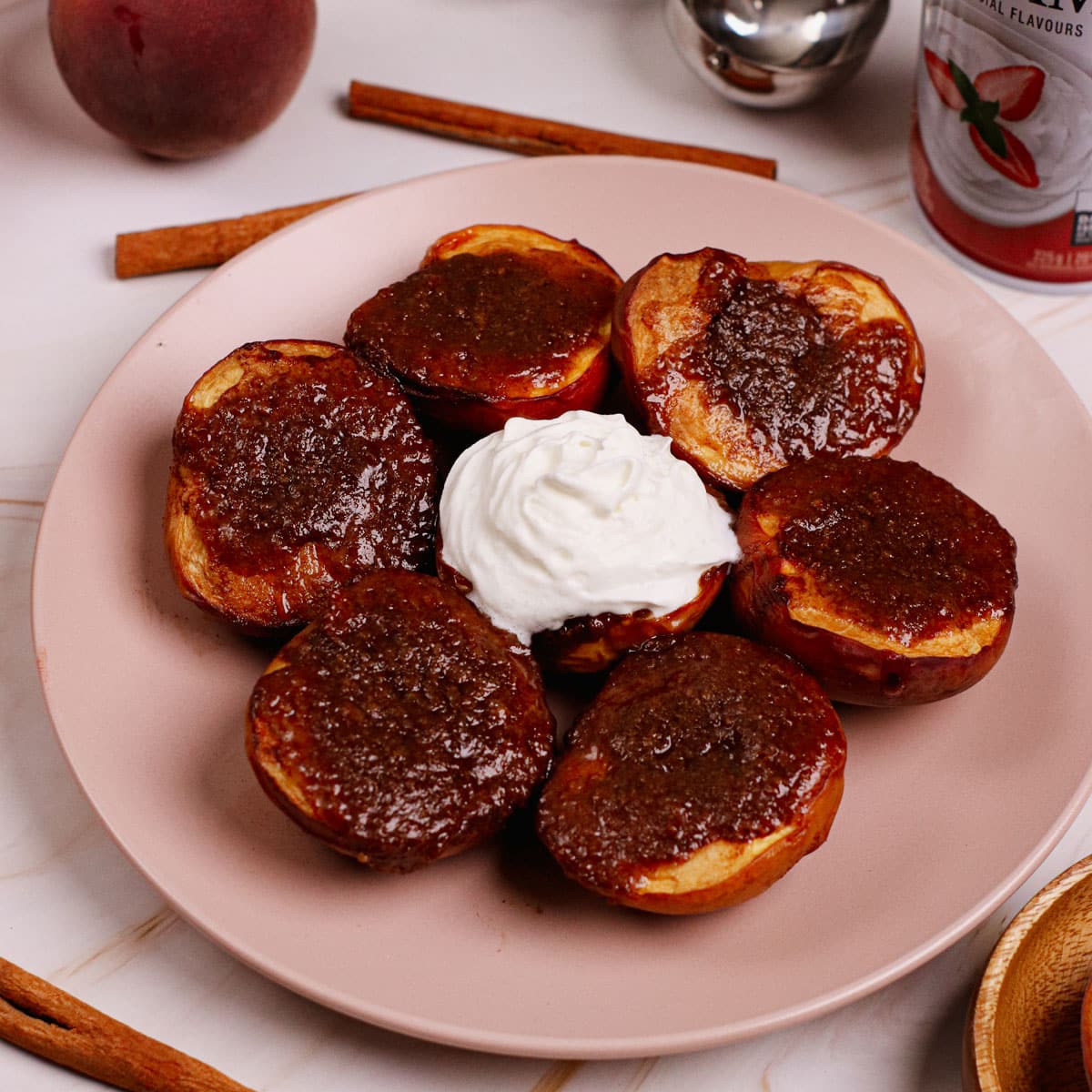 Air fried grilled peaches, one with whipped cream.