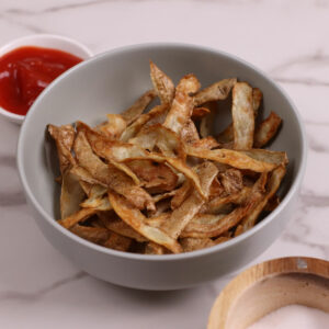 Air fried potato skin chips with ketchup on the side.