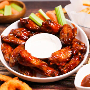 Air fryer BBQ chicken wings served with ranch dipping sauce, celery and carrots.