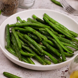Air fryer green beans on a white plate.