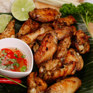 Air fryer lemongrass chicken wings, served on a banana leaf with savory and spicy Thai dip.
