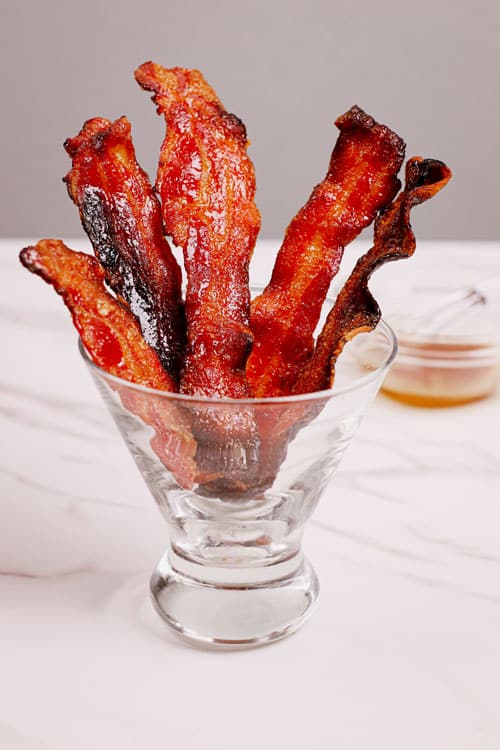 Candied bacon air fryer recipe bite shot served in a cocktail glass.