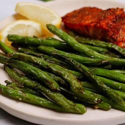 Air fried green beans with cajun salmon and lemon on the side.