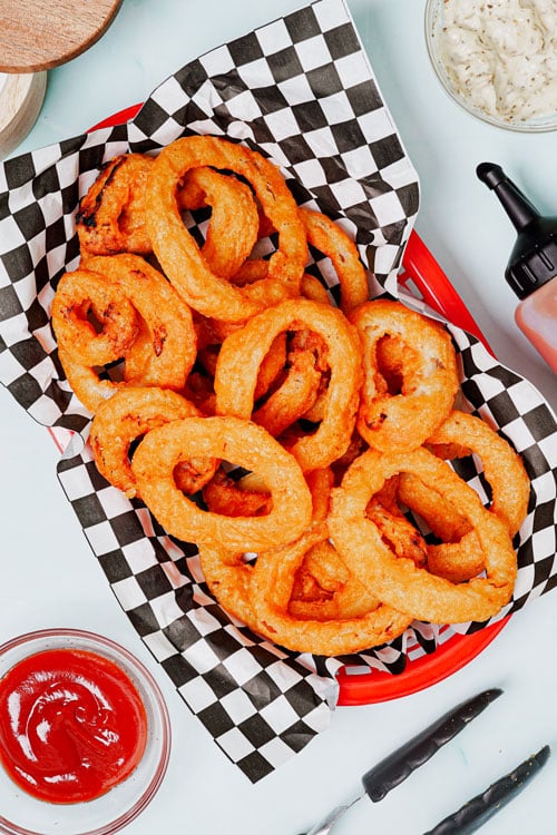 Frozen onion rings in air fryer recipe bite shot with dipping sauce on the side.