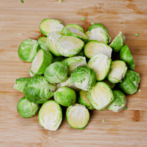 Halved Brussels sprouts on a chopping board.