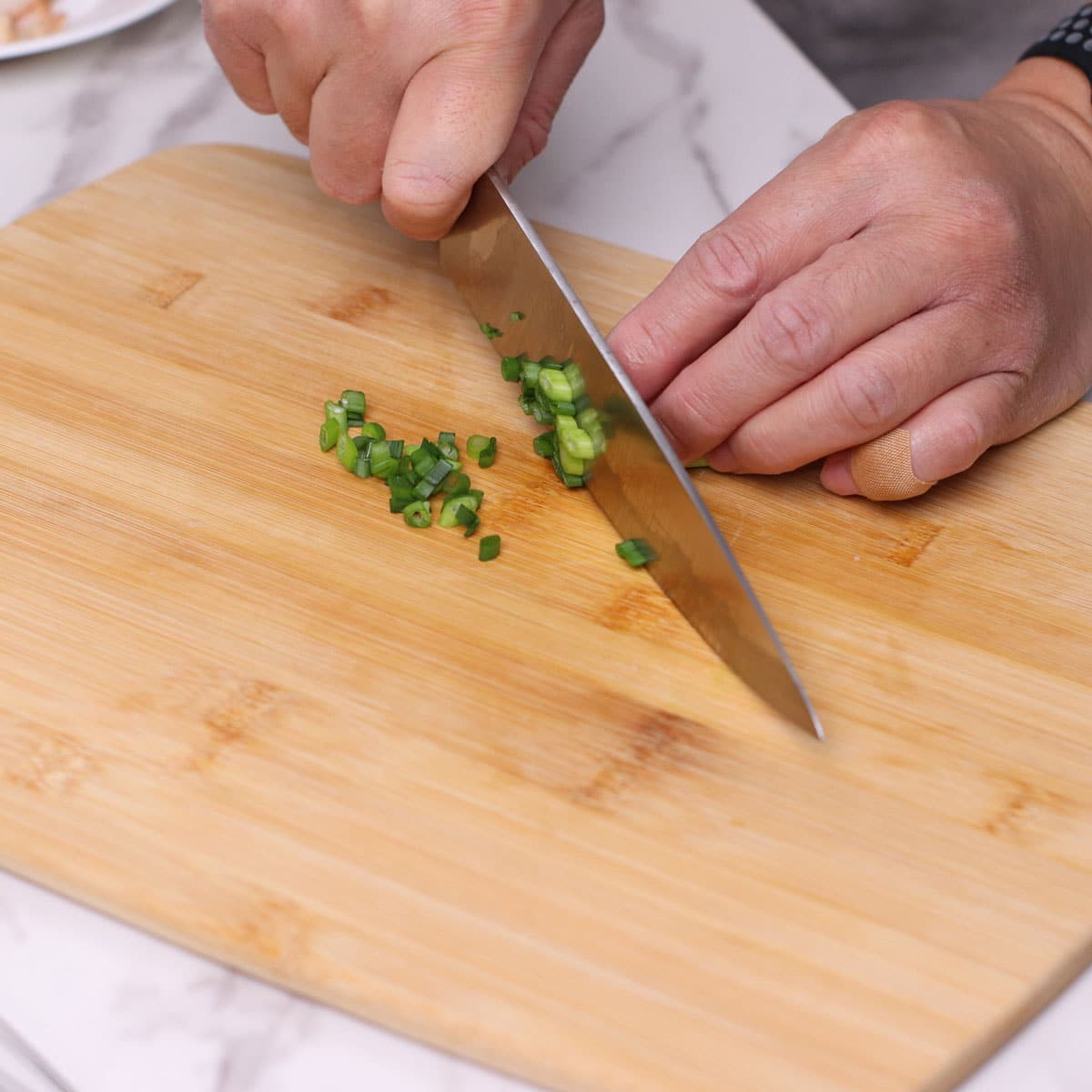 Step 2: Slicing spring onions on a chopping board.