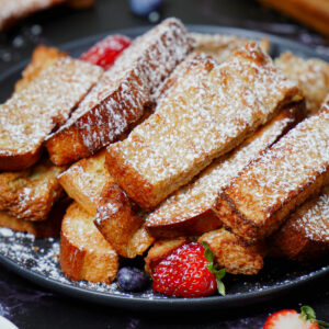 Air fried French toast sticks with powdered sugar and fresh berries.