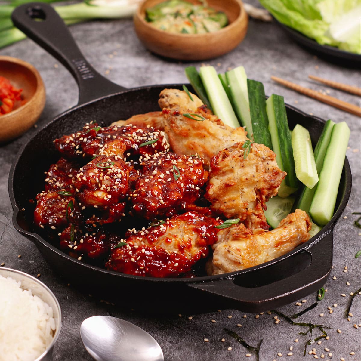 Air fried Korean chicken wings served with celery sticks, a bowl of rice and kimchi.