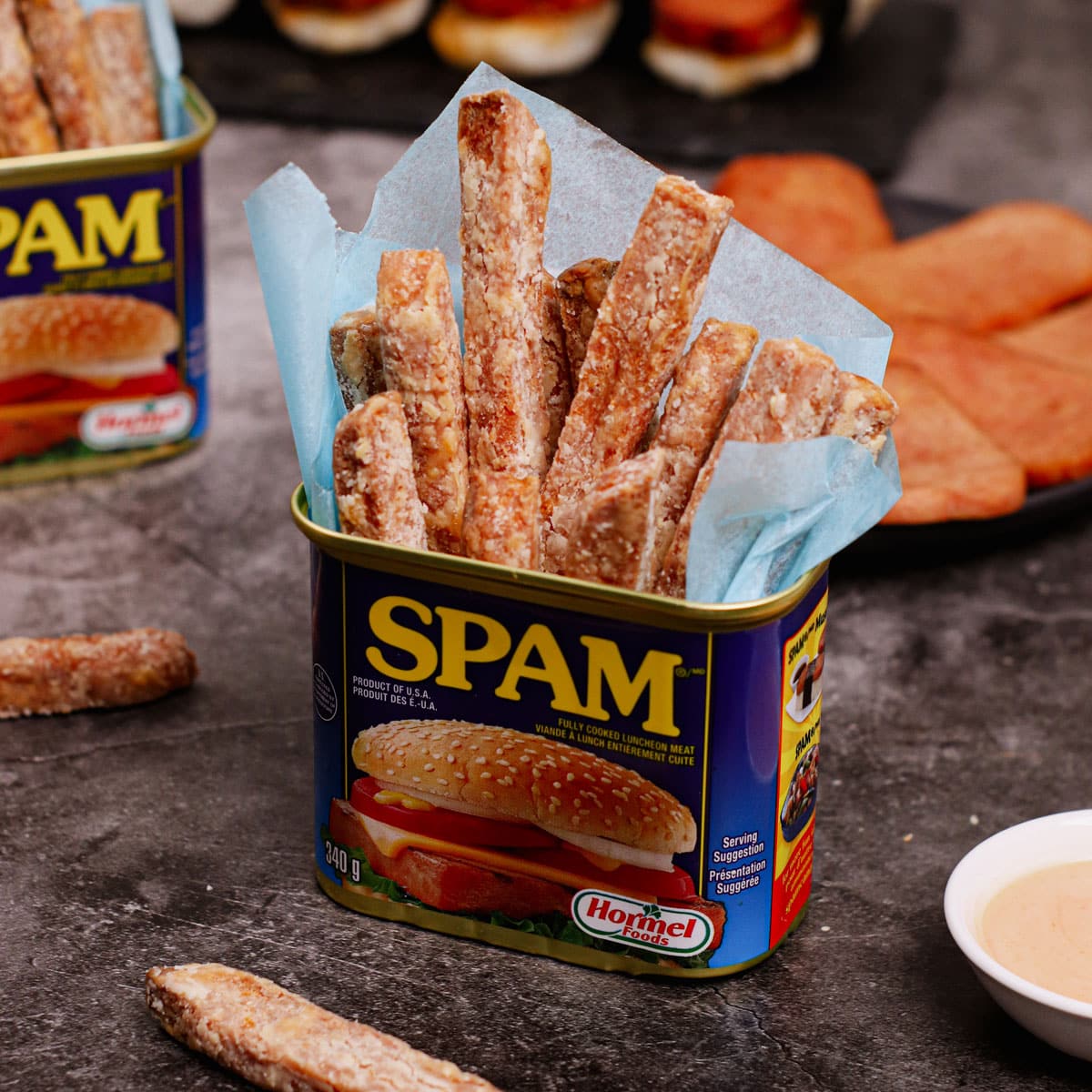 Air fried spam fries served in a can of spam with fry dipping sauce on the side.