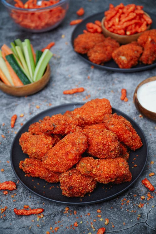Air Fryer Flamin' Hot Cheetos Chicken Wings recipe bite shot, in a black plate with ranch dip.