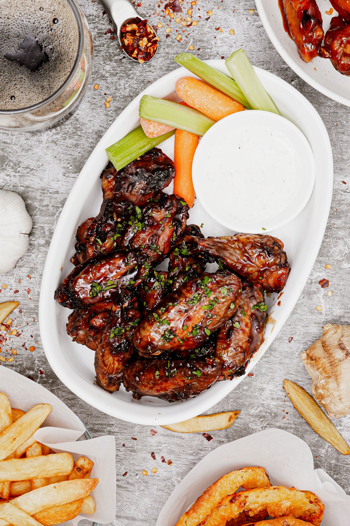 Air fryer honey garlic chicken wings recipe biteshot, on a serving dish with carrots, celery sticks and ranch dipping sauce.