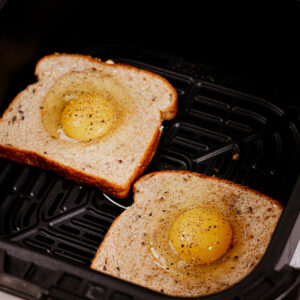 Assembled egg toasts in air fryer basket