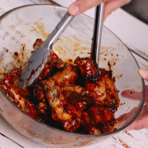 Coating air fried chicken wings with Mongolian sauce.