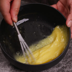 Beating egg wash in a medium bowl