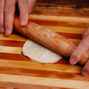 Step 7: Flatten the spring onion pancake gently with a rolling pin.