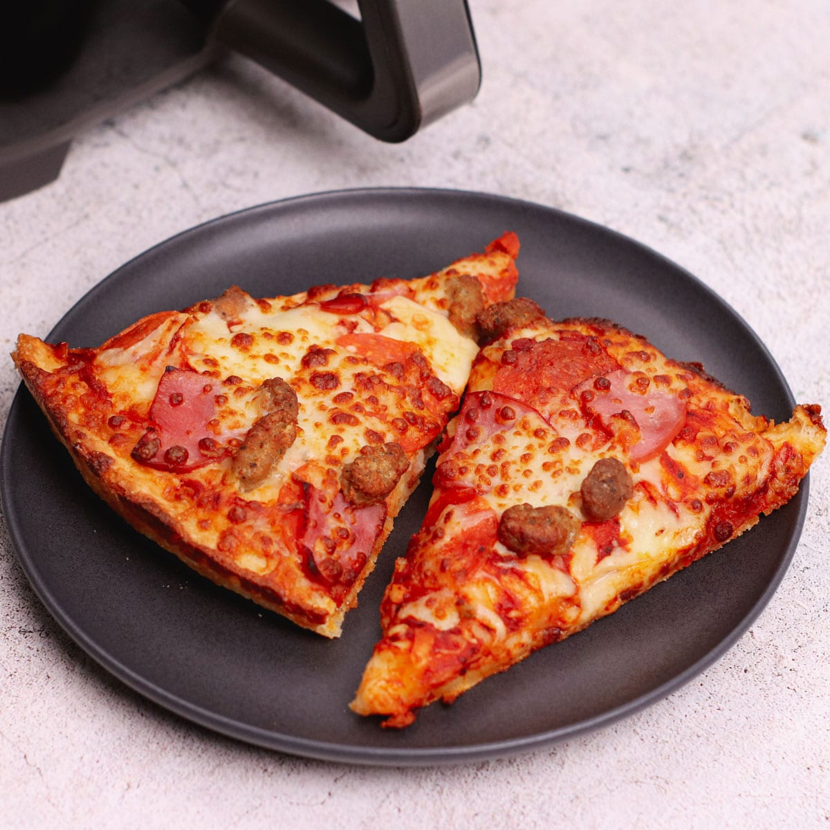 Reheated pizza slices in a black plate