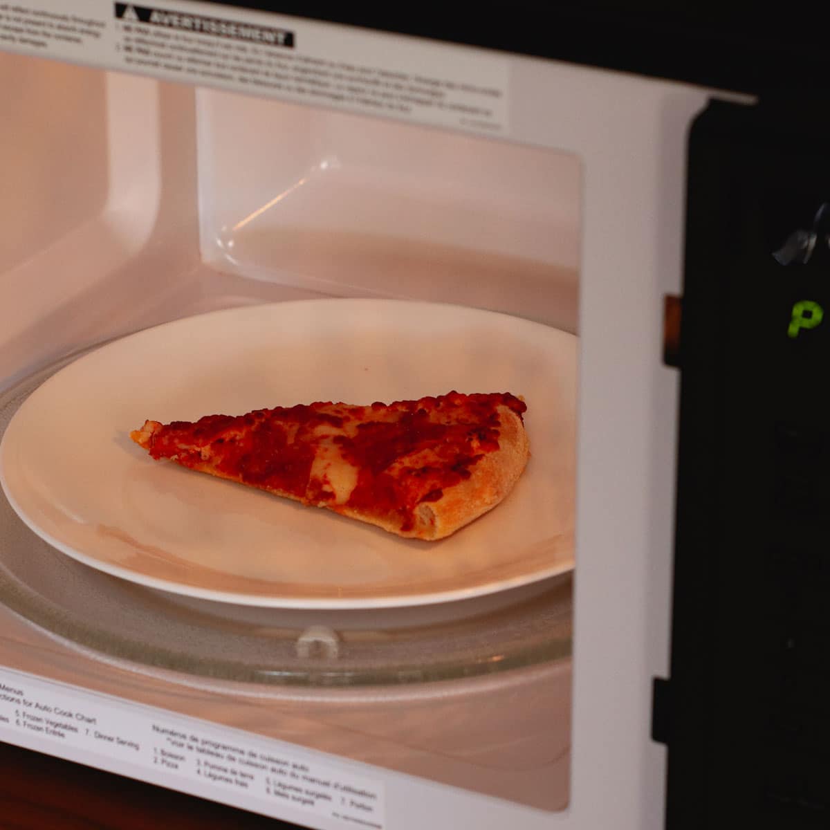 Reheating a pizza slice in the microwave.