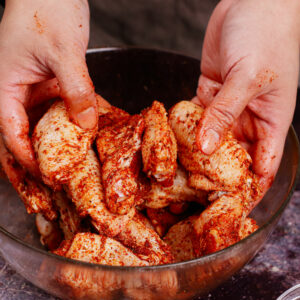 Rubbing chicken wings with Cajun seasoning