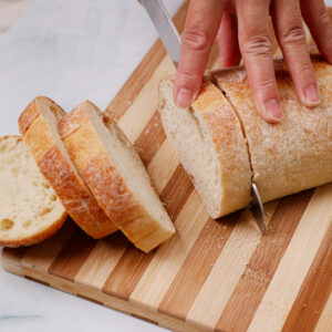 Slicing bread on a chopping board.