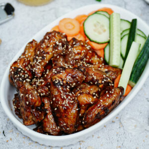 Air fried teriyaki chicken wings with carrots and celery sticks.