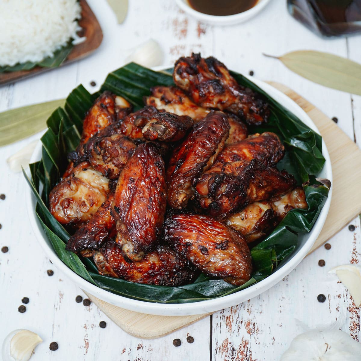 Air fryer adobo chicken wing served on a plate with banana leaf.