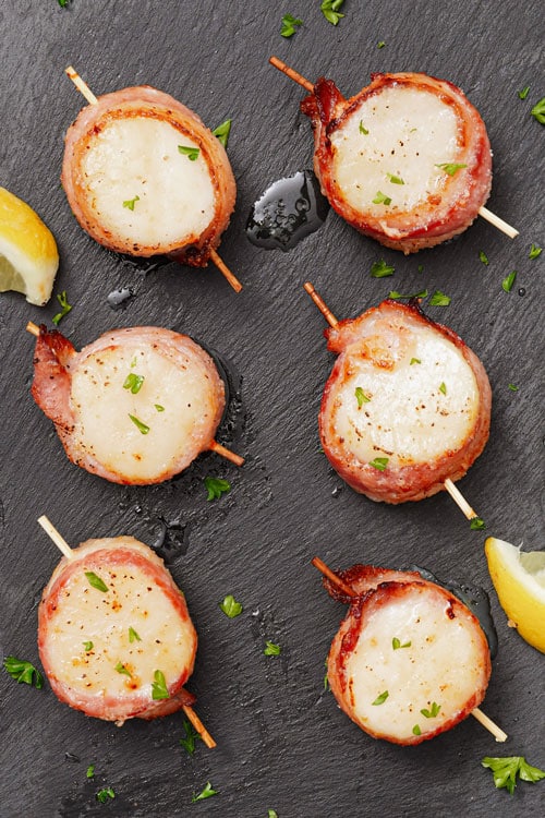 Air Fryer Bacon Wrapped Scallops Recipe: served with lemon wedges and garnished with parsley