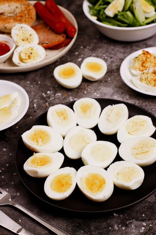 Air fryer hard boiled eggs recipe bite shot with multiple serving options: deviled eggs, salad, breakfast