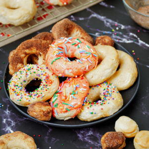 Air fryer Pillsbury biscuit donuts on a plate with assorted flavors.