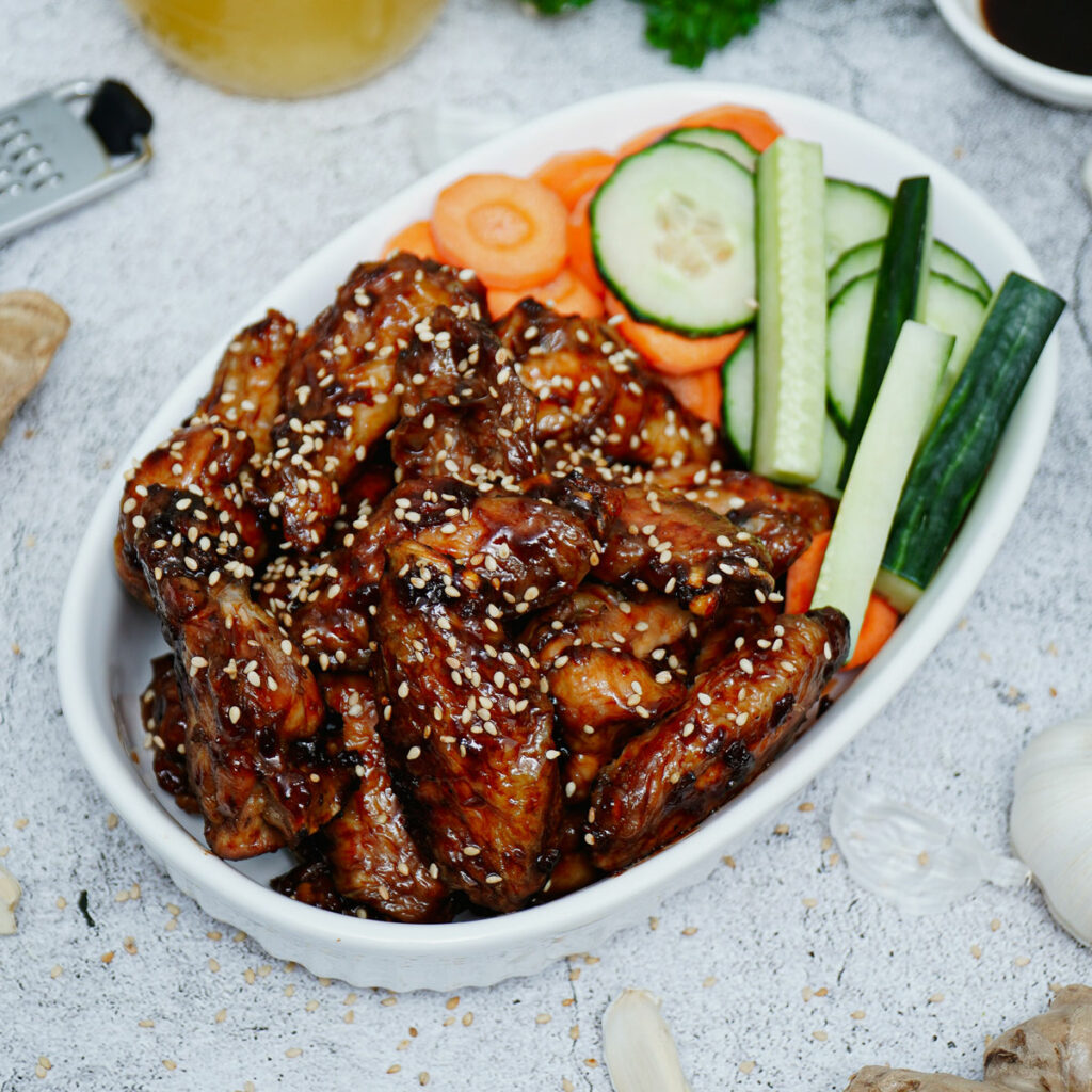 Air fryer teriyaki chicken wings with carrots and celery sticks.