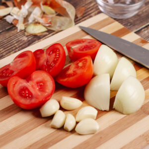 Chopped tomatoes, onion and garlic on a chopping board