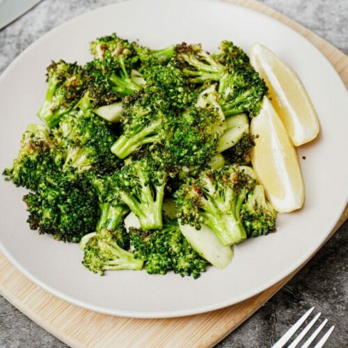 Air fryer broccoli recipe bite shot served with lemon wedges
