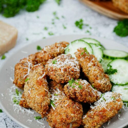 Air fryer garlic parmesan wings recipe bite shot with cucumber slices on the side.