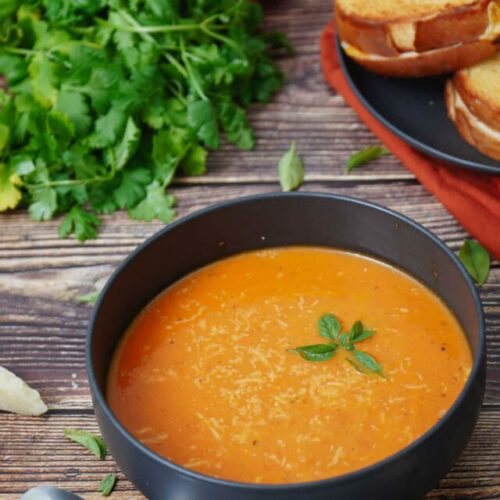 Air Fryer Roasted Tomato Soup recipe served in a black bowl with a side of toast